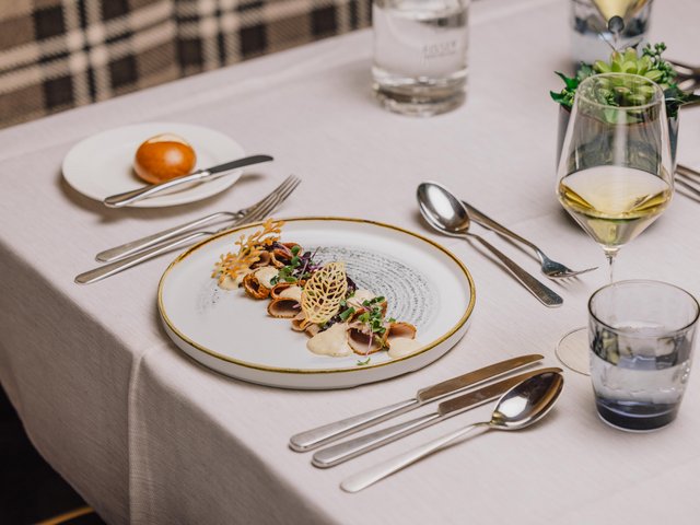 Gedeckter Tisch mit Vitello Tonato und Glas Weisswein