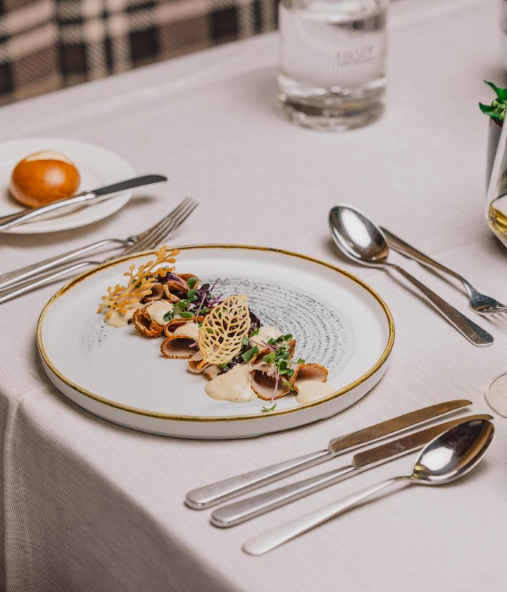 Gedeckter Tisch mit Vitello Tonato und Glas Weisswein